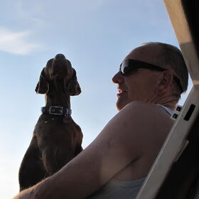 Voor op de boot bij baas op schoot en maar relaxen